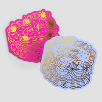 The Jenna Rae Cakes Happy Birthday Greeting Card set includes two cake-shaped cards—one pink with For You and one lavender with Happy Birthday—both featuring gold foil icing, candles, and stars on a light gray background.