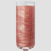 A champagne flute sparkles with a rose-gold drink, shimmering from Jenna Rae Cakes Lucky Penny Edible Glitter—20g containers, package of 3—set against a light gray background.