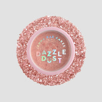 A round shaker of Jenna Rae Cakes Lucky Penny Edible Glitter (5g), with a pink lid featuring iridescent lettering, surrounded by sparkling pink glitter flakes. The pack includes 6 shakers. The background is light gray.