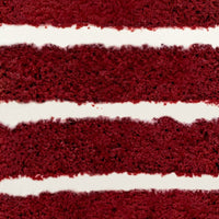 Close-up of Jenna Rae Cakes Red Velvet Cake, highlighting its moist, red-brown layers and thick, smooth cream cheese frosting in between.