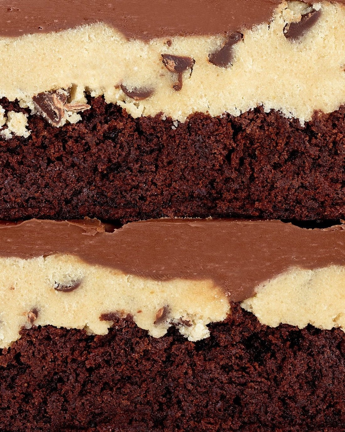 A close-up of Jenna Rae Cakes’ Brownies for 2: two stacked brownie bars layered with chocolate chip cookie dough and finished with a smooth chocolate topping.