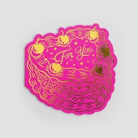 The For You Greeting Card by Jenna Rae Cakes features a bright pink cake shape with yellow and gold icing, cherries, and “For You” in the center, displayed on a plain light gray background.