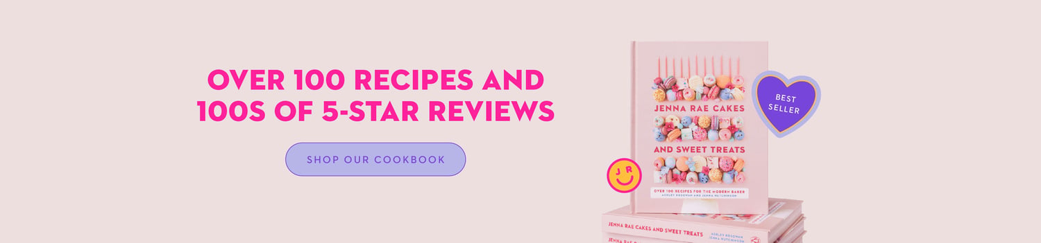 A cookbook titled Jenna Rae Cakes and Sweet Treats sits atop a stack. Bold pink text reads, Over 100 recipes and 100s of 5-star reviews. A purple heart says Best Seller. A button below says Shop Our Cookbook.