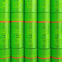 Packages of Jenna Rae Cakes Liquid Candy Melon, each containing six bright green cylinders with bold text and circular patterns, are stacked together to create a vibrant, repeating display.