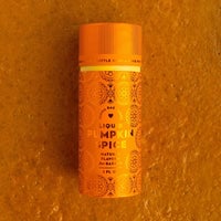 A small orange bottle of Jenna Rae Cakes Liquid Pumpkin Spice rests on an orange textured surface, adorned with decorative patterns and labeled as a natural baking flavor.