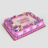 The Sugar Flower Sheet Cake by Jenna Rae Cakes is a rectangular cake with purple icing, pink and purple flowers, green leaves, and “The Past is Prologue (Gladia’s Version)” written in the center.