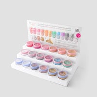 A White Acrylic Dazzle Dust Stand by Jenna Rae Cakes holds colorful pigment powders in small round containers, with a color chart and product info card displayed at the back. Package of 1.