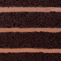 Close-up of a slice of Jenna Rae Cakes’ Chocolate Lovers Cake, featuring four thick layers of moist chocolate cake separated by smooth chocolate frosting.