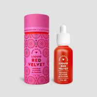A 1 fl oz dropper bottle of Liquid Red Velvet by Jenna Rae Cakes is displayed beside its decorative pink and red cylindrical packaging on a light gray background.