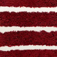Close-up of Jenna Rae Cakes Red Velvet Cake, highlighting its moist, red-brown layers and thick, smooth cream cheese frosting in between.