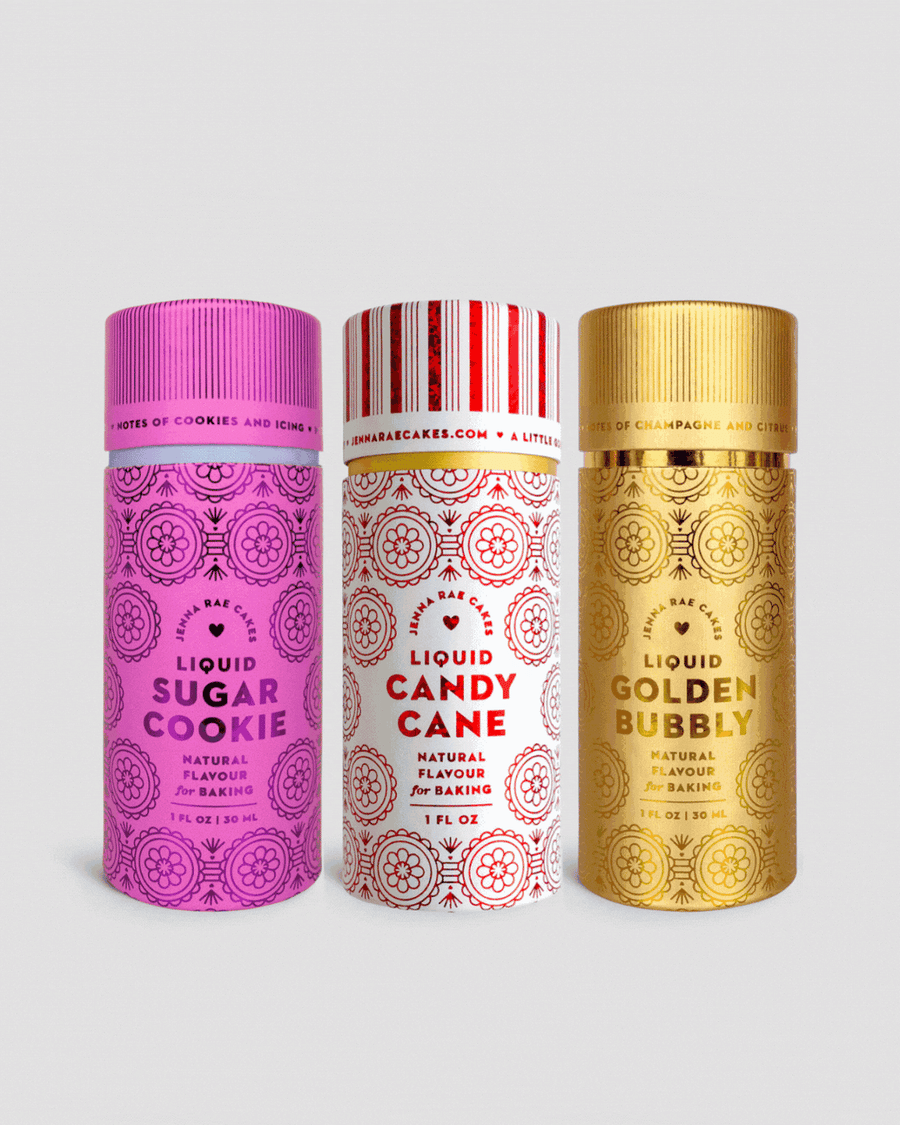 Three vibrant Build Your Own Liquid Flavour Trio bottles by Jenna Rae Cakes—Sugar Cookie (pink), Candy Cane (red/white), and Golden Bubbly (gold)—stand side by side, each with bold text and decorative patterns on the front.