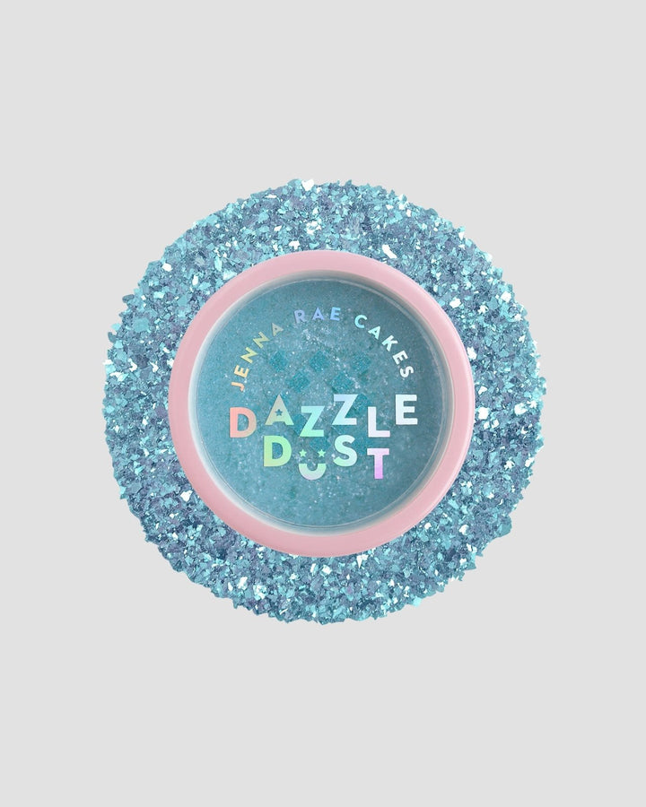 A round Jenna Rae Cakes Blue Sky Edible Glitter 5g shaker with a pink rim is filled and surrounded by sparkling blue glitter on a light gray background; sold as a package of 6.