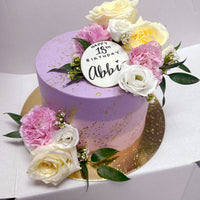 Design This Cake - Size: 8" | Exterior Colour: Ombre (Top Colour: Lavender. Bottom Colour: Soft Pink)| Buttercream Finish: Smooth | Add Metallic Splatter: Metallic Gold | Flower Colour Palette: Designers Choice