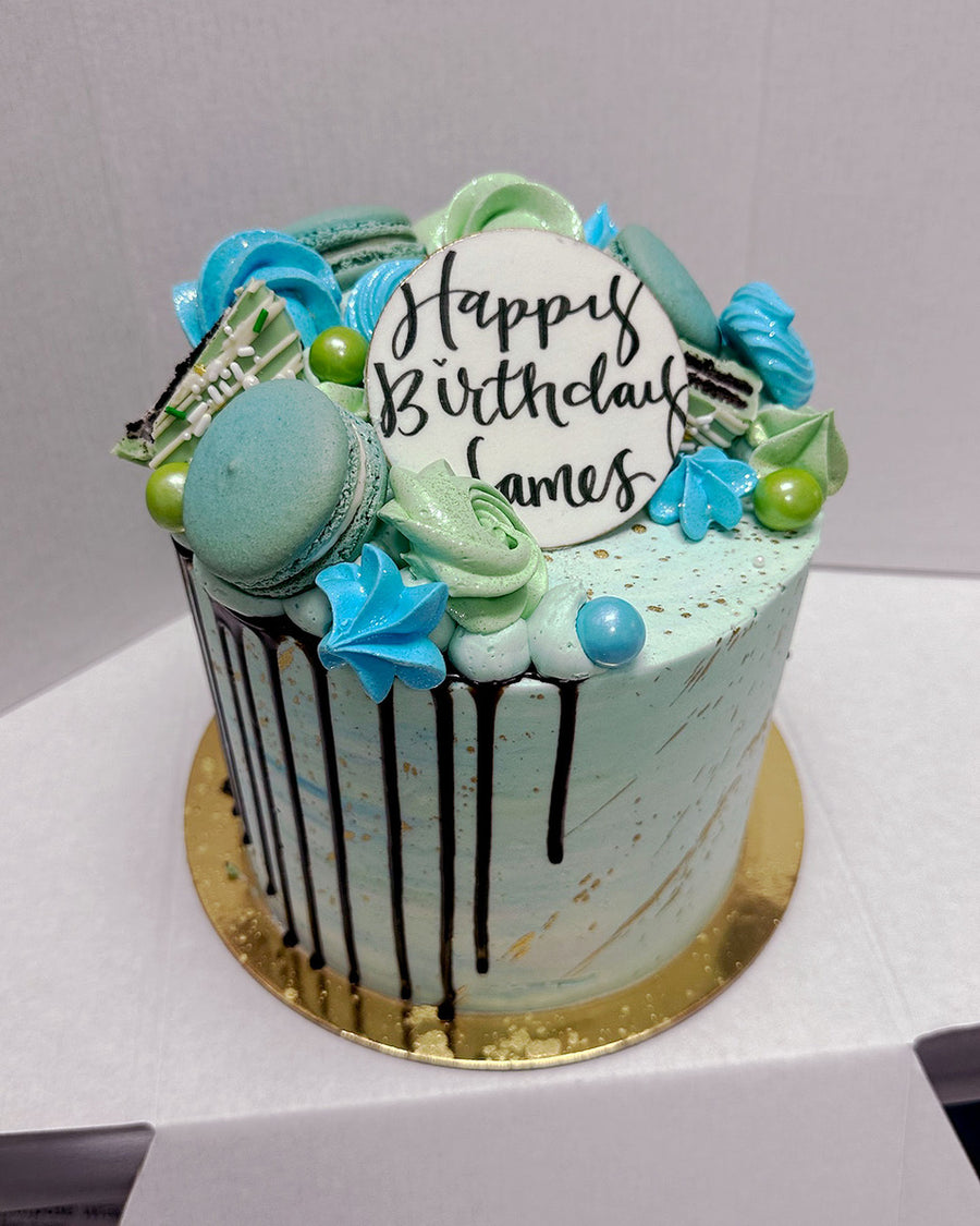 Design This Cake - Size: 6" | Colour Palette: Blues/Greens | Add Metallic Splatter: Metallic Gold | Chocolate Drip: Chocolate Ganache | Add Greeting Plaque