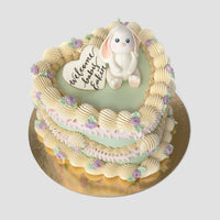 Design This Cake - Size: Tall | Cake Colour: Soft Sage Green | Piping Colours: 2 Piping Colours | Piping Colour 1: White | Piping Colour 2: Soft Pink | Rosette Colour:  Lavender | Animal Topper: White Baby Bunny