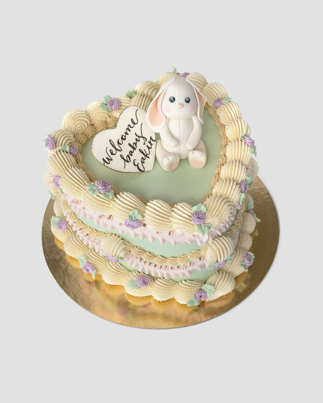 Design This Cake - Size: Tall | Cake Colour: Soft Sage Green | Piping Colours: 2 Piping Colours | Piping Colour 1: White | Piping Colour 2: Soft Pink | Rosette Colour:  Lavender | Animal Topper: White Baby Bunny