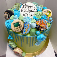 Design This Cake: Size: 8" | Select Colour Palette: Blues/Greens | Chocolate Drip: Baby Blue | Upgrade to Printed Macarons | Add Greeting Plaque