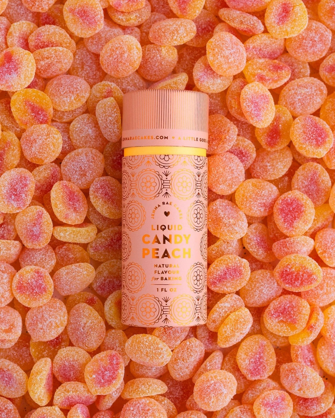 A package of 6 Jenna Rae Cakes Liquid Candy Peach containers rests on sugar-coated peach gummies. The pink and orange labels display decorative patterns and natural flavors information.