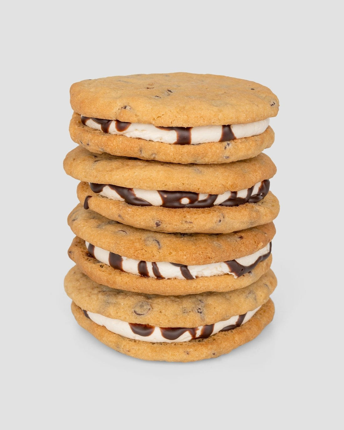 A stack of five Jenna Rae Cakes Regular Cookie Sandwiches, filled with vanilla cream and chocolate sauce, displayed against a plain light gray background.